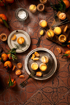 flat lay of pastries just baked and filled with home made orange curd and thyme, sprinkled with icing sugar, styled with fresh tangerine