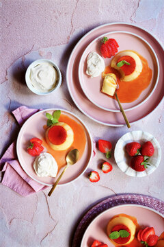 Cr&egrave;me caramel classic French custard dessert topped with a layer of soft caramel sauce and served with strawberries, apple mint and whipped cream.