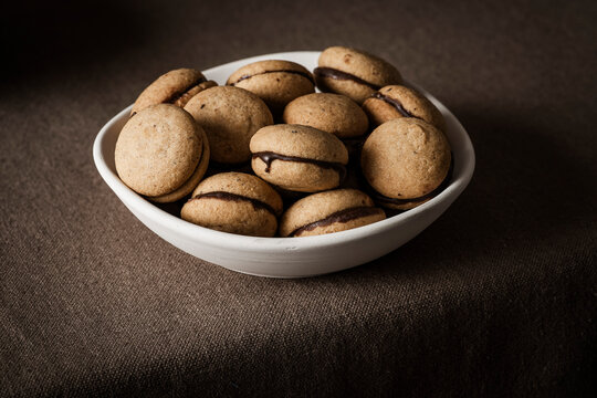 Italian 'Baci di dama', shot from the front to highlight their shape and the thin layer of chocolate cream that joins the two halves.