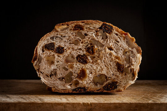 Close-up of a slice of artisanal bread with walnuts and figs.