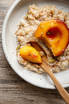 Stewed peach served over creamy oats with seeds and toppings