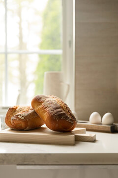 Fresh artisan bread loaves resting on a kitchen cutting board