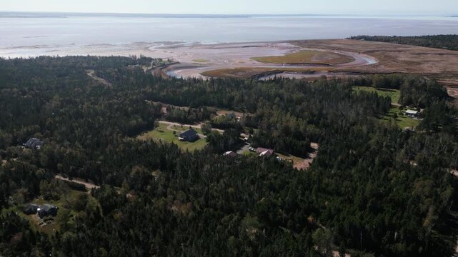 Aerial coastal village Portapique Nova Scotia Canada with forest homes near Bay of Fundy. Extreme tides create stunning coastal patterns and peaceful rural landscape