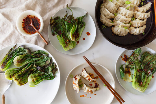 Asian dumplings with grilled bok choy and chili oil, overhead view