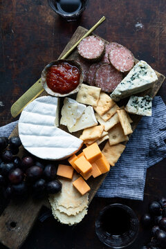 Cheese and charcuterie board with crackers, grapes, and wine