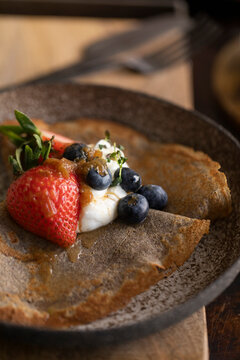 Buckwheat crepes topped with strawberries, blueberries, and yogurt