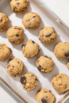 Chocolate chip cookie dough balls on white background on angled tray
