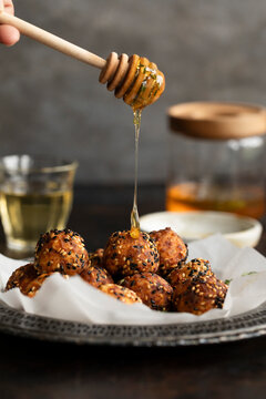 Cretan feta balls drizzled with honey and sesame on rustic plate