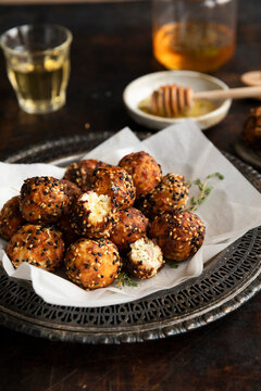 Cretan feta balls with honey and sesame on rustic plate