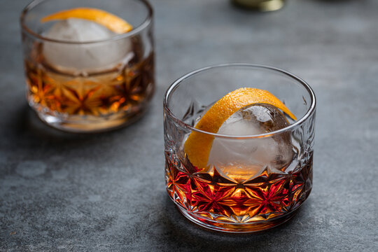 Bourbon Chambord cocktail with spherical ice and orange twist