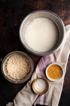 Dosa ingredients including rice and urad arranged in metal bowls