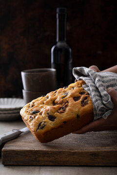 Olive oil loaf cake with olives on rustic board