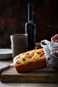 Olive oil loaf cake with olives on rustic board