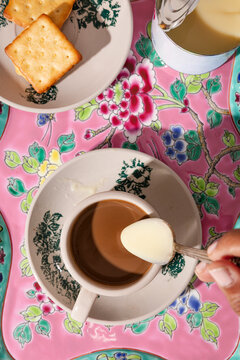 Condensed milk spooned into a cup of Singaporean kopi