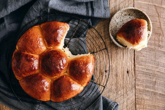 Fresh Japanese milk bread buns on rack with rustic cloth