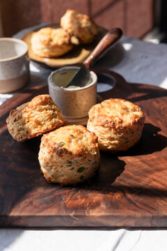 Golden cheddar scallion biscuits on rustic wooden board