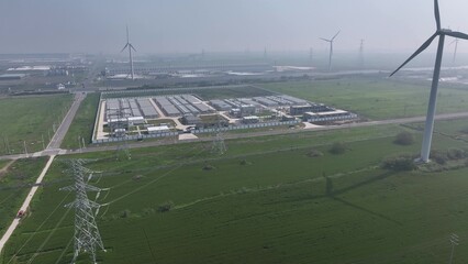 aerial view of energy storage station and wind turbines in green fields © zhu difeng