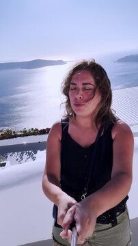 Woman making duck face on santorini vlogging vacation