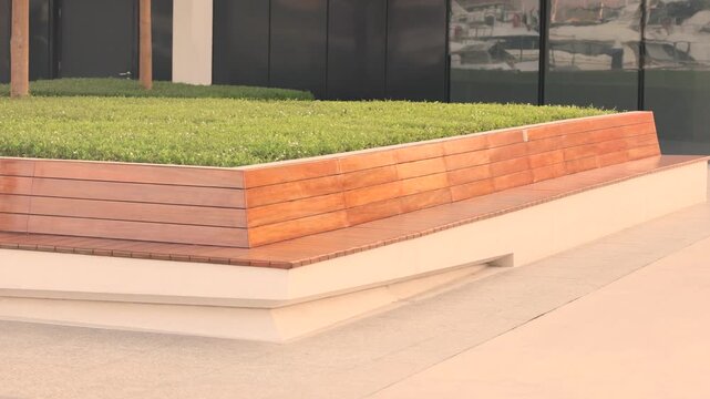 Modern wooden bench with green lawn in contemporary urban park design