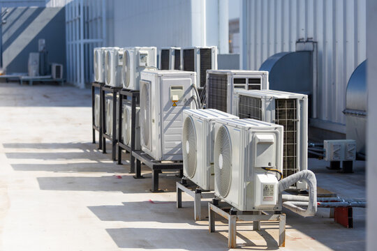 Modern outdoor air conditioner compressor units, Row of industrial air conditioning units on a building rooftop, External hvac system installed on the roof of a modern commercial office