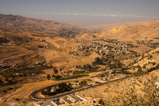 High angle view of a winding road and rural village in the arid mountain landscape near Al-Karak, Jordan