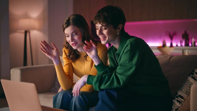Two girls waving laptop web camera finish virtual call sitting home sofa closeup