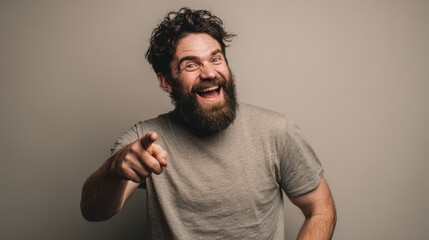 Obraz premium Confident bearded male portrait: laughing with direct gaze and a pointed gesture toward the camera