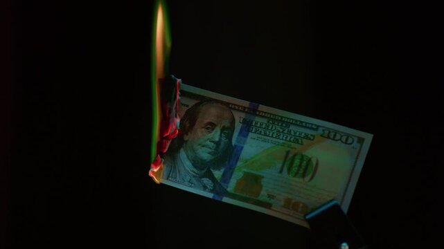Burning dollar paper bill. Hundred dollars goes up in flames. USD , financial loss and waste. Collapse of the economy, democracy and capitalism. Inflation and depreciation of the US currency.