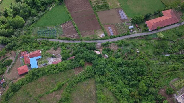 Aerial video featuring  a patchwork of farm fields, rural tracks, and houses in Katund i Vjeter within the Mirdita Region.