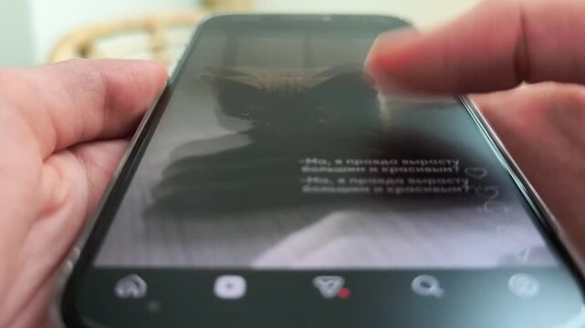 Hands scroll a smartphone screen in close up. A finger swipes through mobile social media content on a modern phone. Digital browsing and app engagement concept for online marketing..