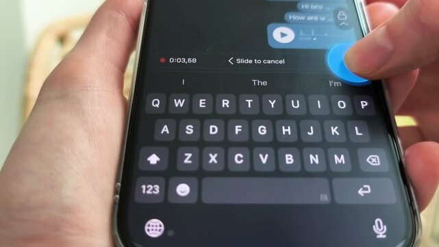 Phone close up with hands holding smartphone, tapping microphone icon in messenger for recording voice message