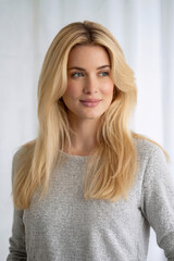 Naklejka premium Beautiful Blonde Woman with Natural Smile in Gray Sweater Clean White Background Lifestyle Portrait