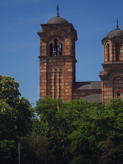 Naklejka premium beautiful view of the old green and yellow church tower and the rest of the city