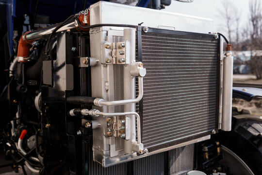 Industrial Vehicle Engine Radiator Assembly with Metallic Cooling Fins and Hydraulic Lines in Close Up