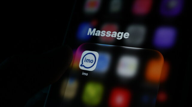 Closeup of a smartphone screen showing the imo messaging app icon in a folder labeled massage
