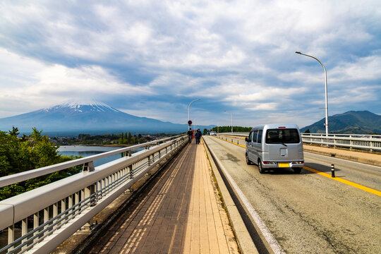 Morning traffic crossing Kawaguchiko Ohashi Bridge with Mt Fuji view. Bridge was voted one of Japan's Top 100 Roads in 1987 due to its picturesque location