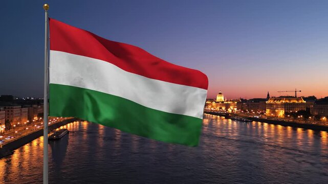 Hungarian flag waving by river at dusk