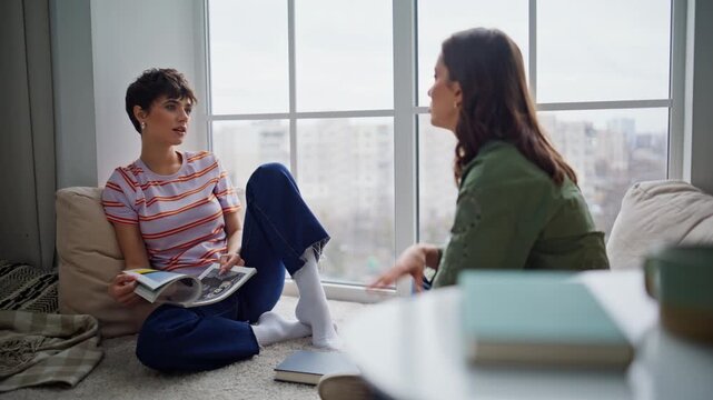 Chilling sisters talking together sitting home floor. Women discussing thoughts
