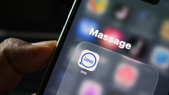 Closeup of a smartphone screen showing the imo messaging app icon inside a folder named massage