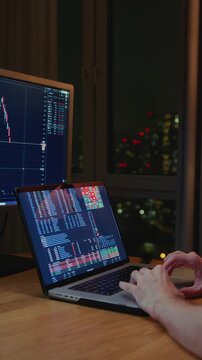 Man trader monitors market charts on laptop, screen and smartphone at home. Analyzing real-time trading data, considering investment strategies. Professional investor engaged in day trading, Evening