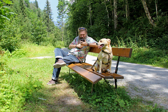 Mann mit seinem Hund und Handy