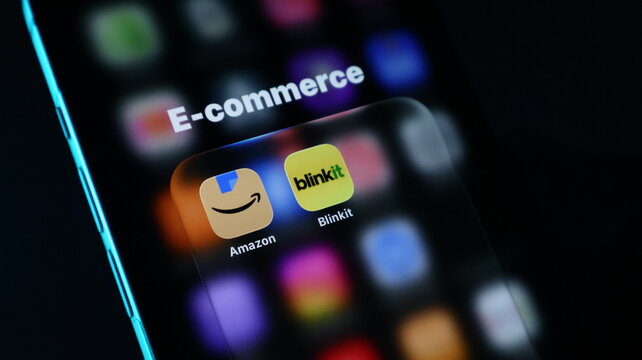Closeup of a smartphone screen displaying ecommerce apps like amazon and blinkit in a folder, representing digital shopping and technology
