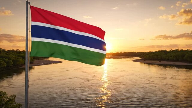 Gambia flag waving by river at sunset