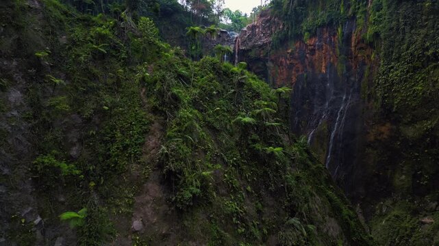 Cinematic aerial view of Tumpak Sewu Waterfall in East Java &ndash; Breathtaking drone shot of massive tropical canyon in warm sunrise light and morning mist, premium Indonesia landscape 4k footage