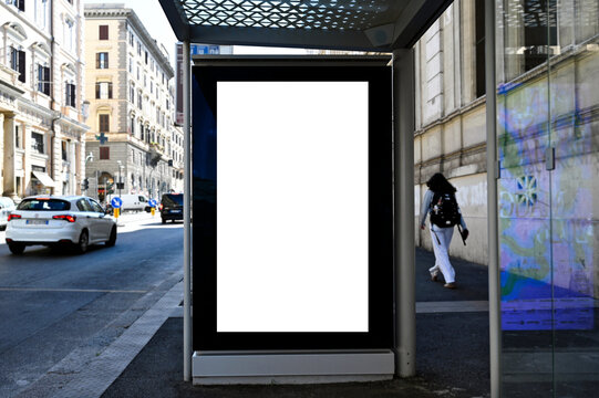 blank digital ad panel. billboard display. empty white lightbox sign at busstop. mockup template. city transit station. urban street setting. outdoor advertising.