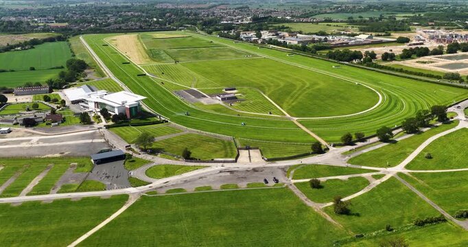 Leeds, Yorkshire 28th May 2026: Aerial drone footage of the Wetherby Racecourse in West Yorkshire UK showing the horse racing circuit green landscape nearby countryside and residential development