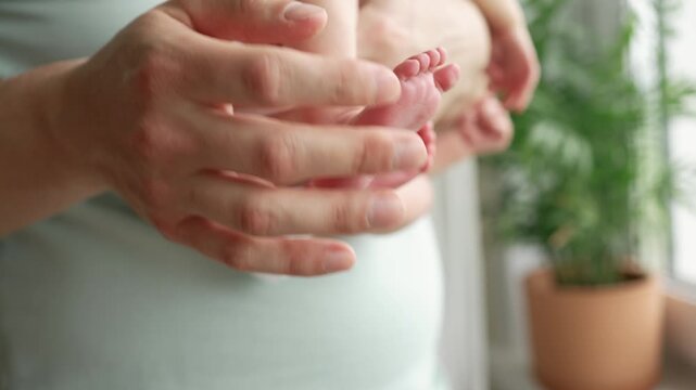 Careful fathers hands gently cradle the tiny legs and feet of a newborn baby. A touching moment of paternal love, showcasing the strong connection and tender care within a new family