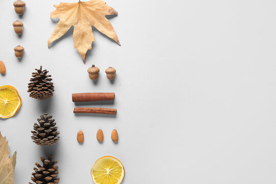 Composition with pine cones, dried orange slices, acorns and cinnamon sticks on grey background