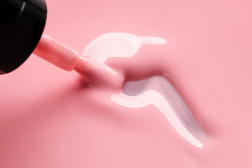 Obraz premium Pink nail polish and brush as background, above view. Space for text