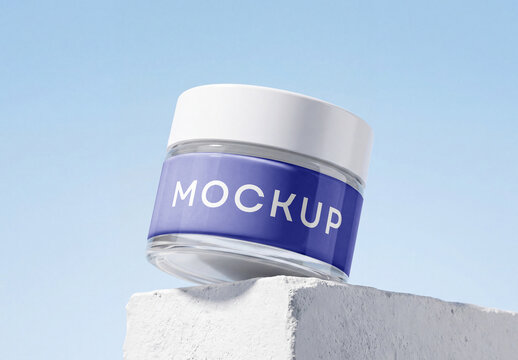 Glass cosmetic jar mockup with white lid standing on a concrete stone podium block with a clear blue sky background